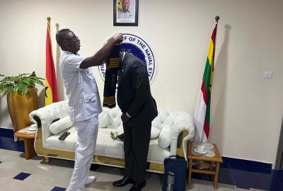 Chief of the Naval Staff, Ben Baba Abdul putting a sash on Prof. Mattah